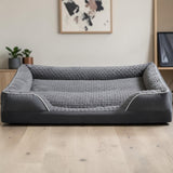 Vue de face du panier orthopédique pour chien grande taille, coloris gris anthracite avec surface en peluche texturée gris clair, rebords rembourrés et liseré blanc, posé sur parquet clair dans un intérieur moderne
