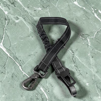 Happy Animalia black nylon adjustable dog seatbelt with elastic shock absorption and metal clips for car travel.