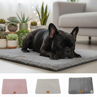 Bouledogue français noir endormi sur le lit orthopédique gris Happy Animalia, avec les 3 coloris disponibles : rose, beige et gris, fond salon lumineux.