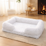 Panier orthopédique et apaisant blanc en fausse fourrure pour grand chien Happy Animalia, posé sur un tapis près d'une cheminée allumée.