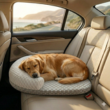 Chien Golden Retriever endormi sur un lit orthopédique gris et blanc installé sur la banquette arrière d'une voiture pendant un trajet.