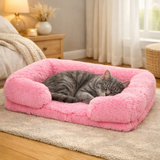 Panier orthopédique et apaisant rose pour chat Happy Animalia, avec un chat gris tigré endormi à l'intérieur, posé sur un tapis dans une chambre chaleureuse.
